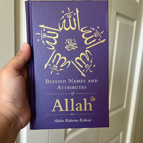 A hand holding a purple book with the title 'Blessed names and attributes of Allah' by Abdur Raheem Kidwai.