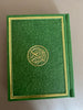 an emerald green quran with gold trim covers in a beautiful, detailed design