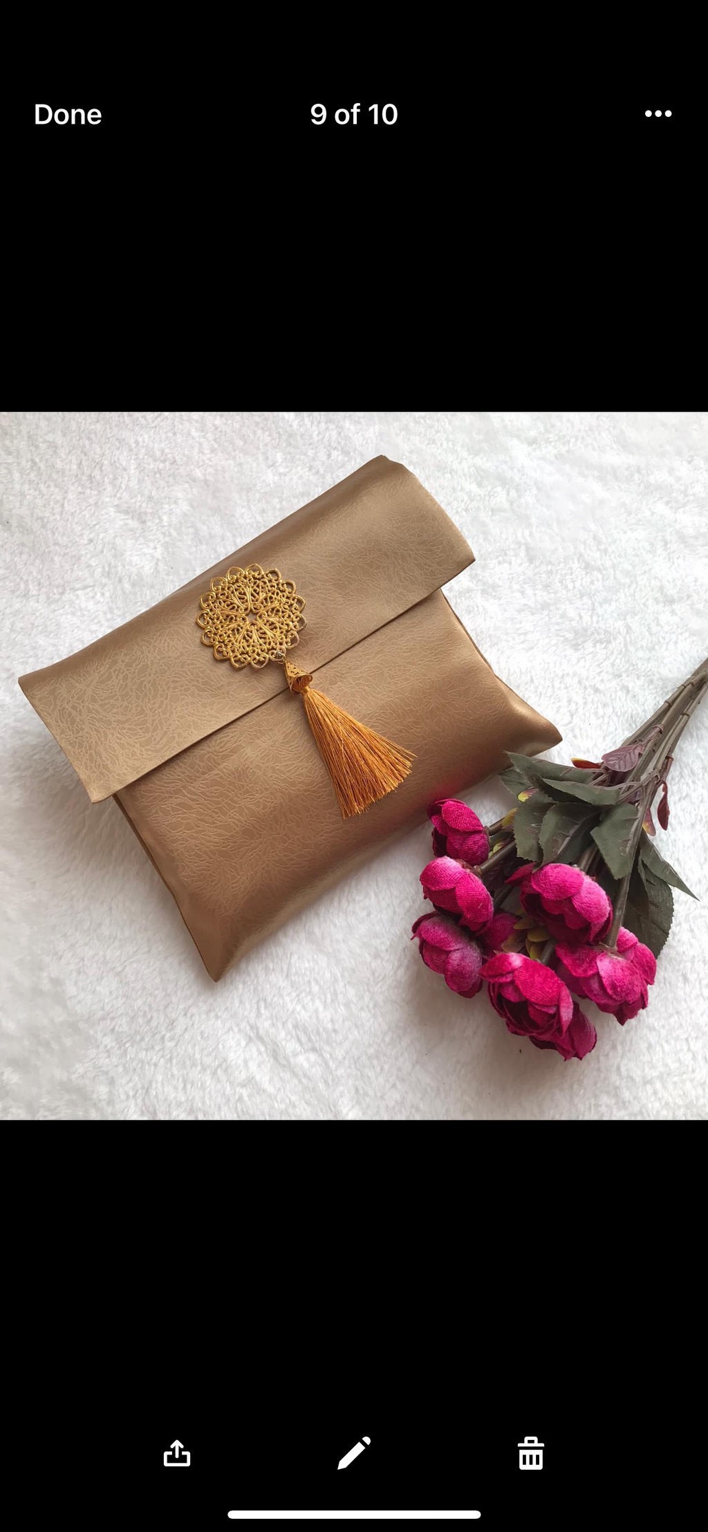a gold prayer mat inside an elegant bag, displayed next to bright pink roses