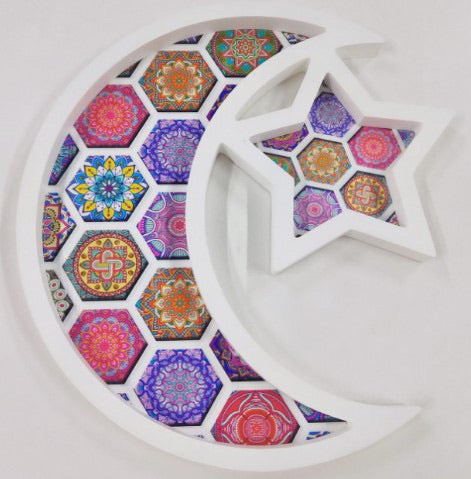 a white serving tray shaped as a crescent moon and star with islamic geometric illustrations